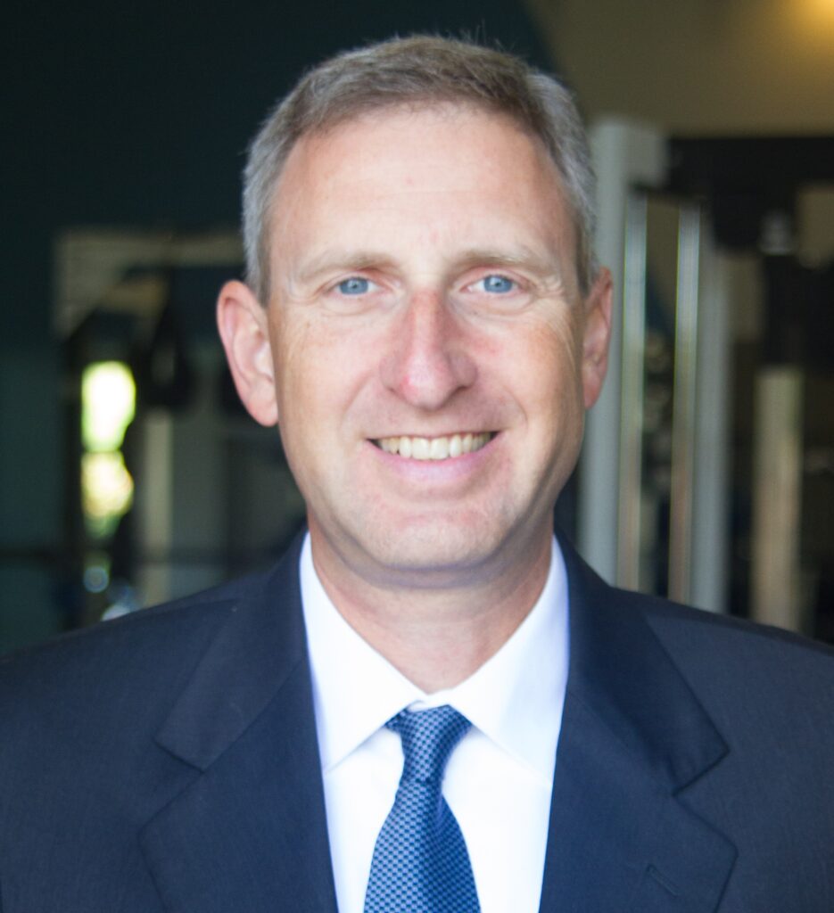 Dr. Doug Maxeiner, chiropractor at Central Ohio Spine and Joint, smiling in clinic gym space